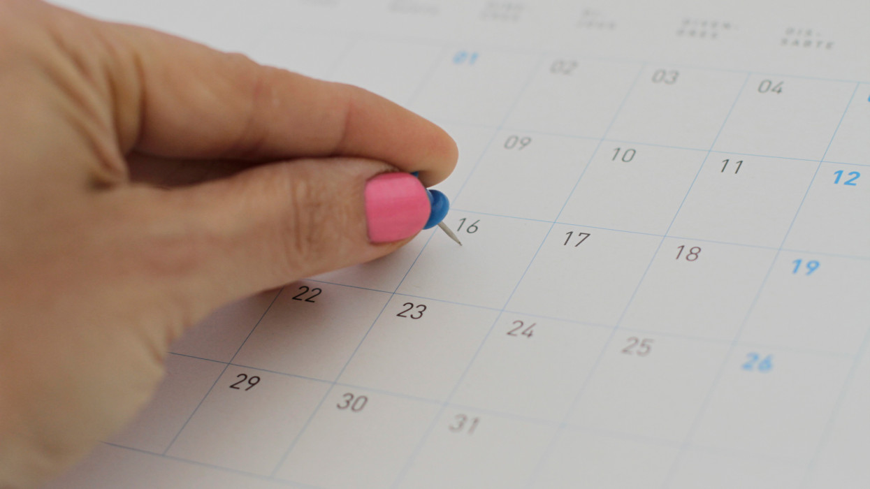 Close-up of woman hand pinning on Calendar Folder