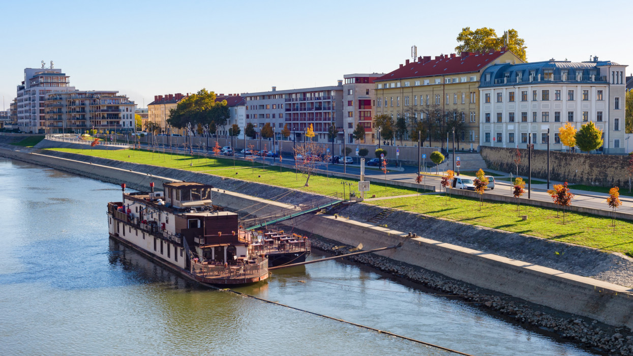 Gyor cirtyscape with ship by Daunbe riverbank in bright sunshine, Hungary