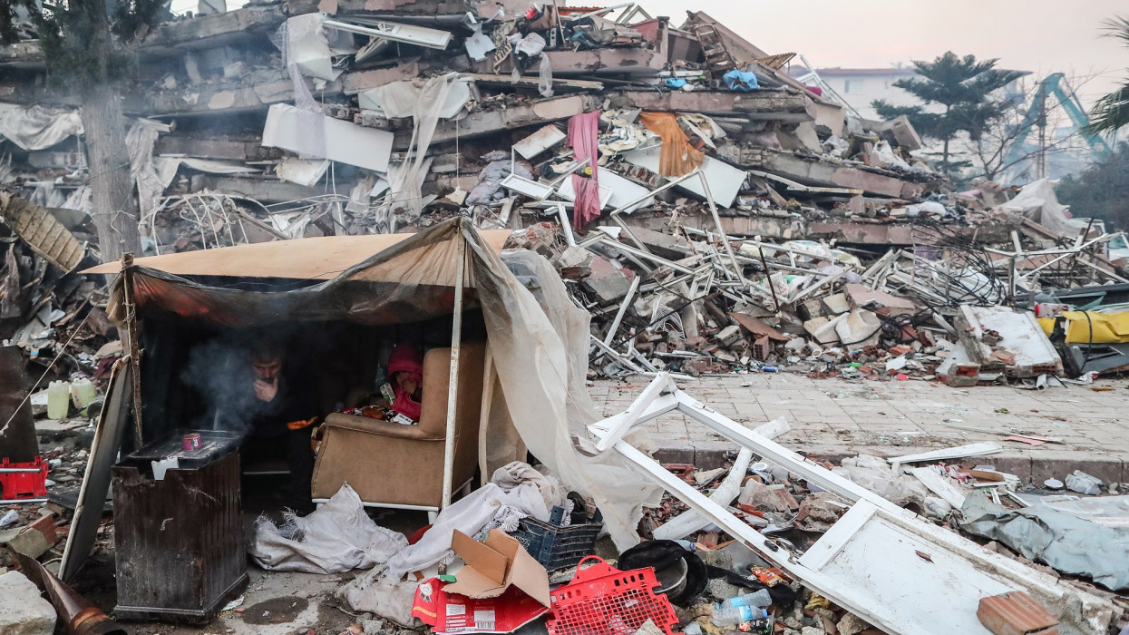 Hatay, 2023. február 8.Összedõlt épületek romjai elõtt felállított sátorban ül egy férfi a dél-törökországi Hatay tartományban 2023. február 8-án. Két nappal korábban több erõs földrengés rázta meg Törökország délkeleti és Szíria északi részét, a természeti katasztrófa halálos áldozatainak száma meghaladja a 9500-at.MTI/EPA/Erdem Sahin