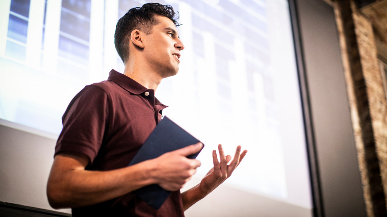 Young professional man giving presentation in modern office space