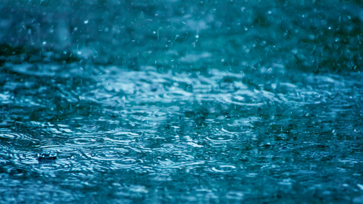 Close-up of a puddle of water with splashing raindrops during a downpour