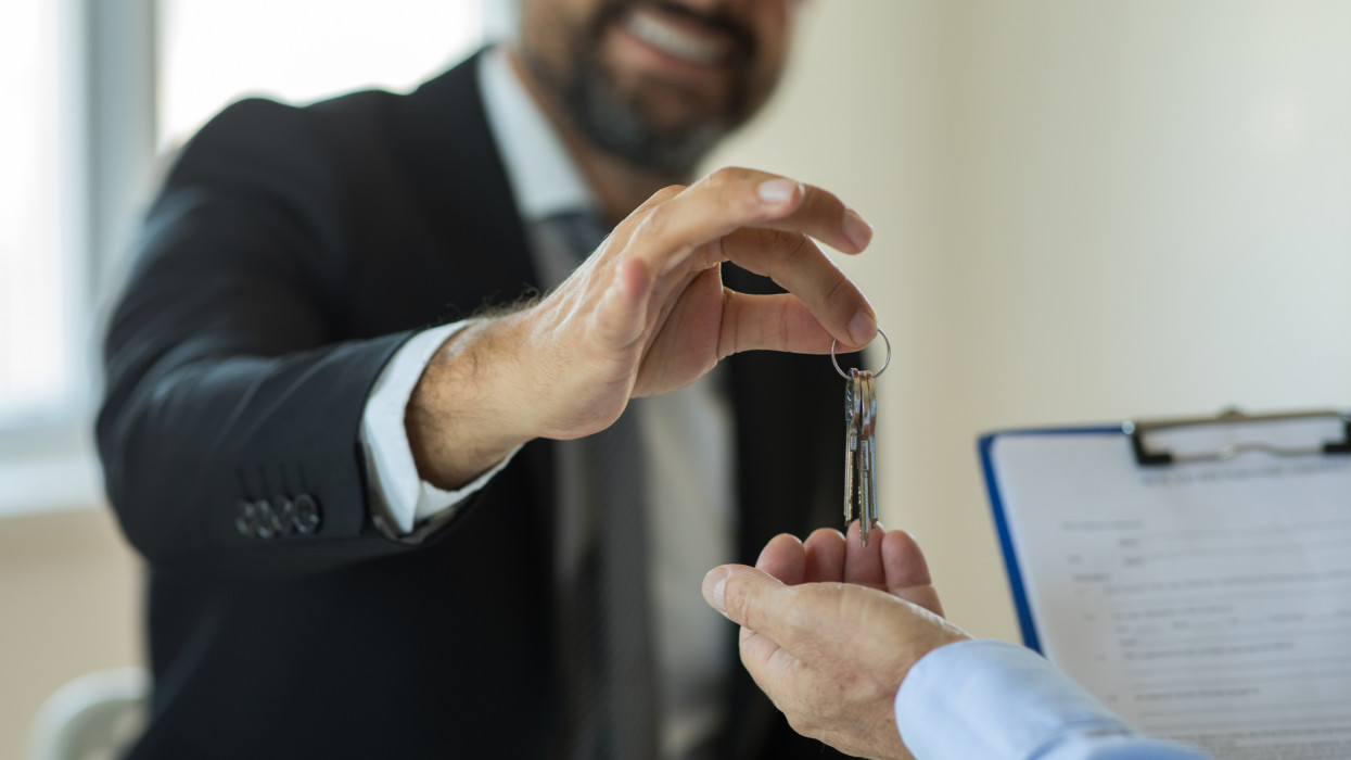 Real Estate Agent hand giving keys to new house owner