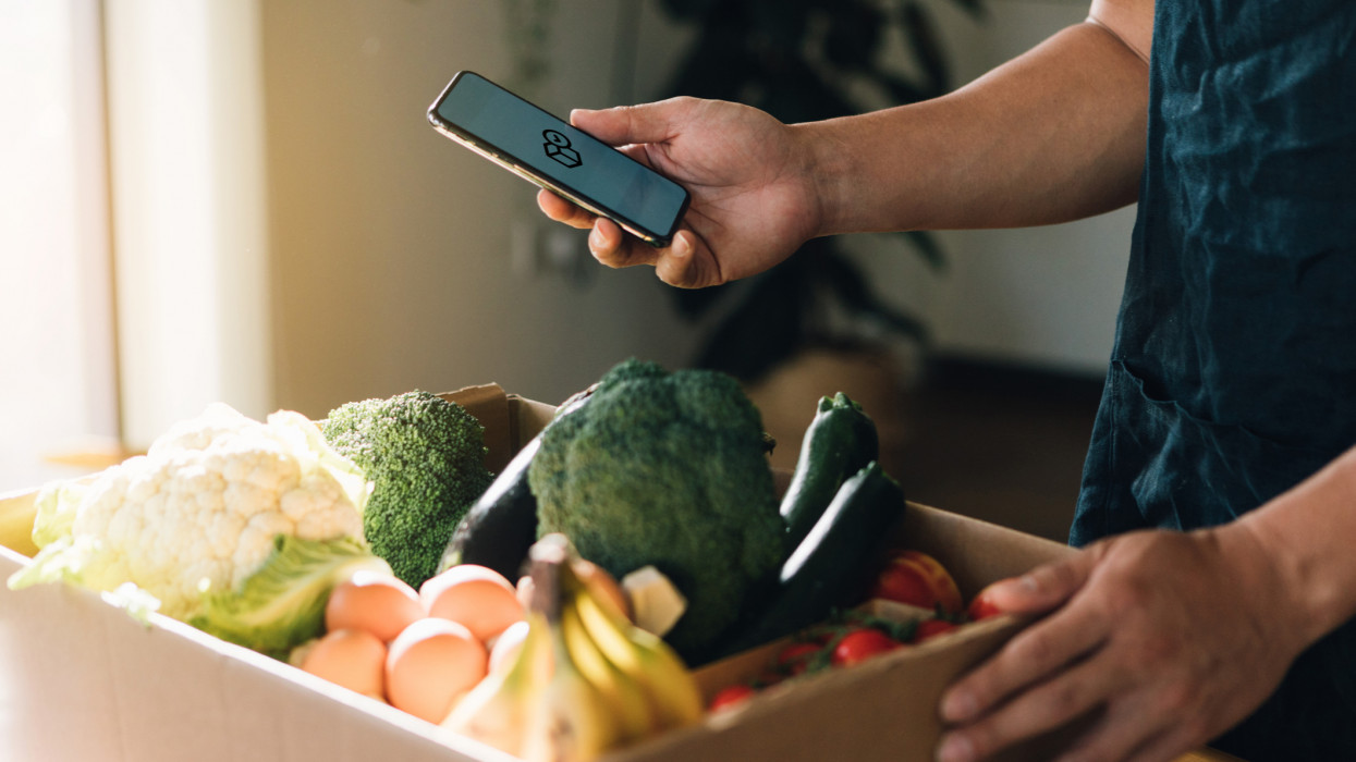 Cropped shot of man using smart phone to order vegetables and fruits delivery online