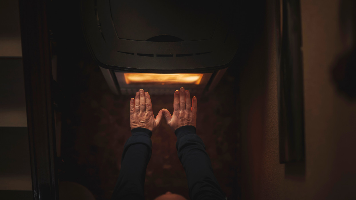 mans hands warming up on an electric stove.