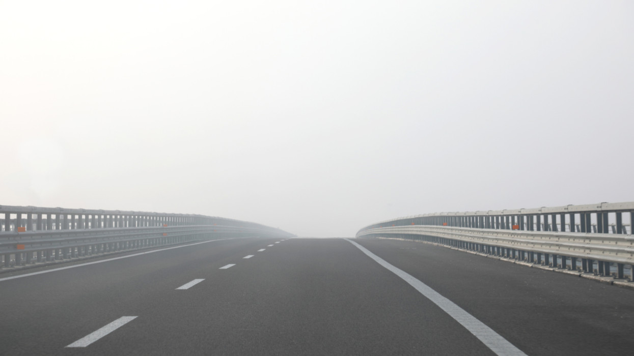highway with very dense dangerous fog without cars during in winter