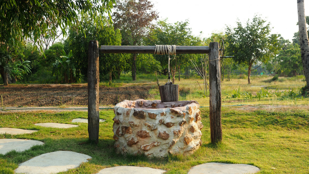 Old countryside water well With Pulley and Bucket.
