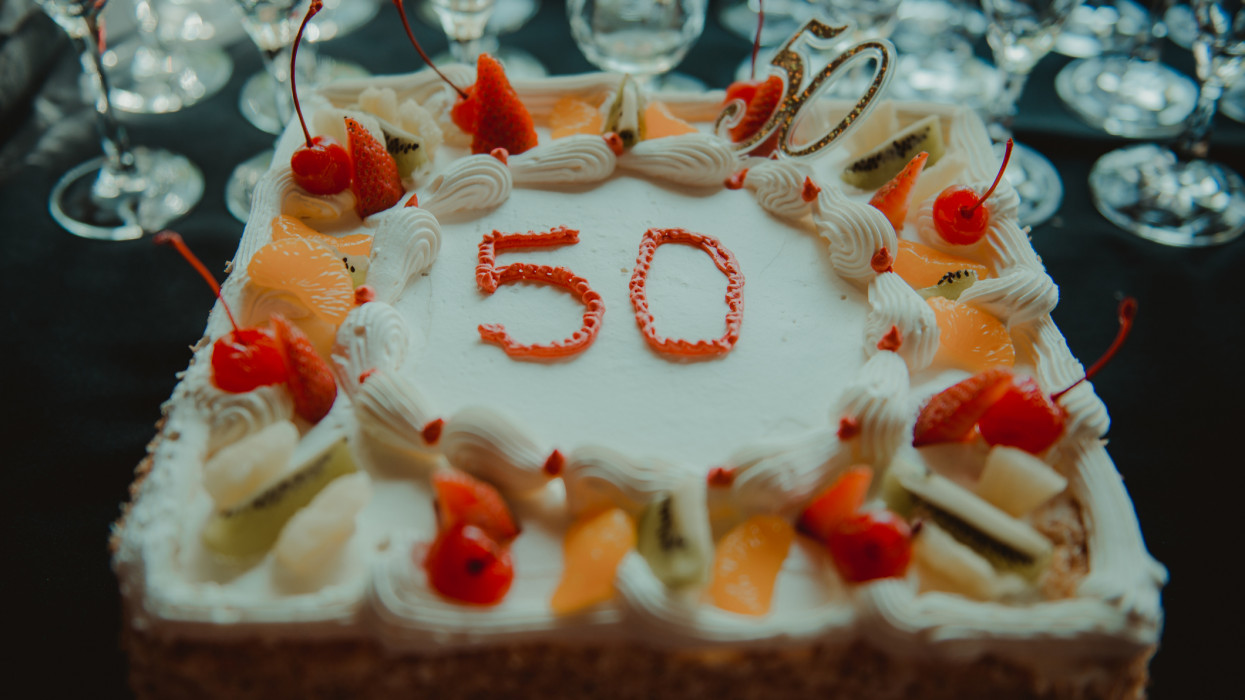 A cake with the number 50 on it adorned with fruit birthday