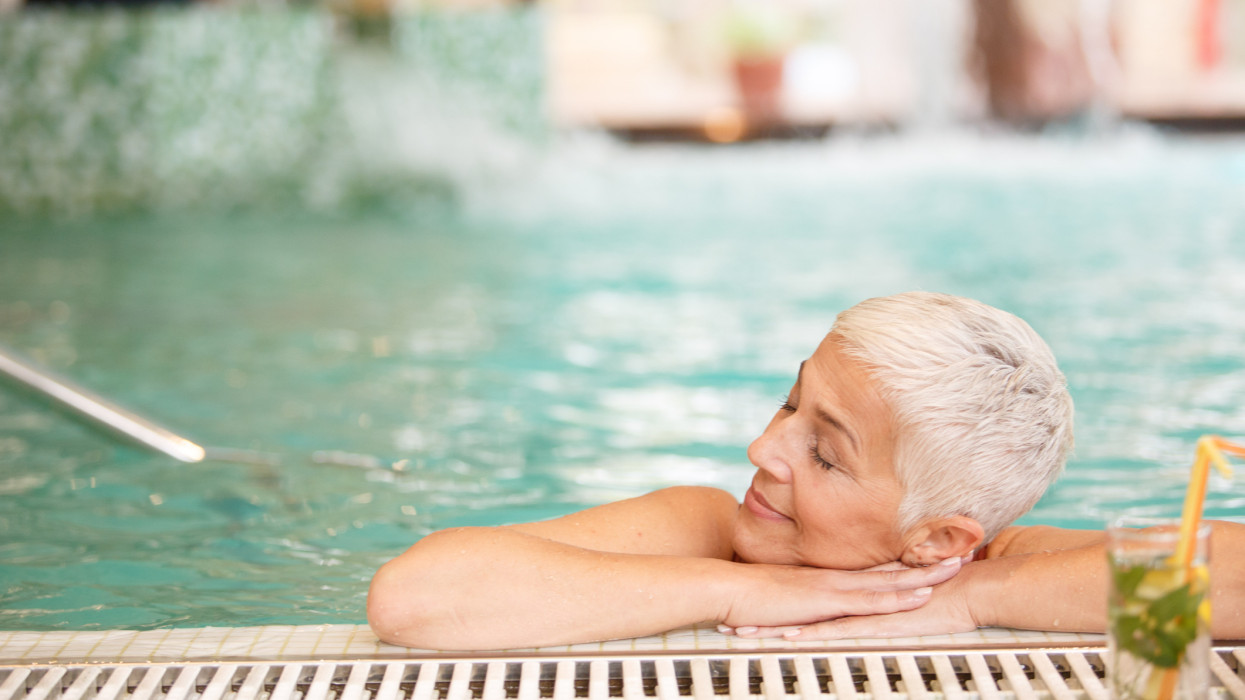 Copy space shot of a mature woman resting in swimming pool with her eyes closed.