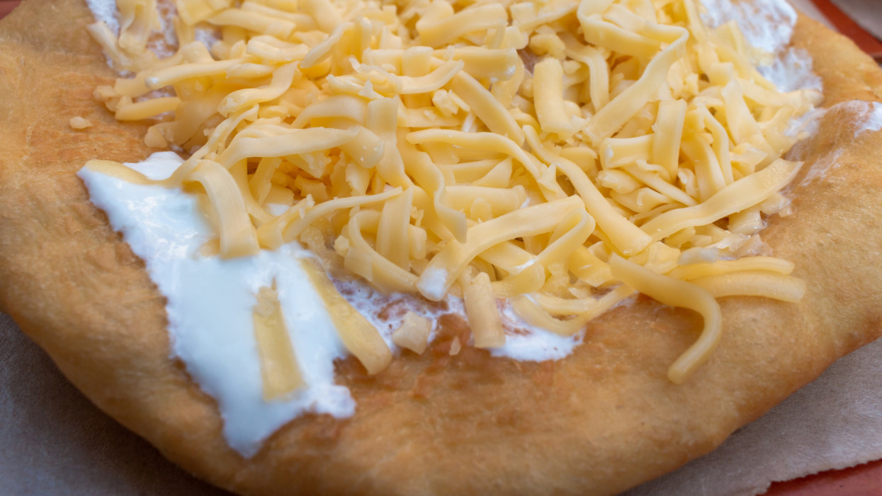 LÃ¡ngos is a deep fried Hungarian flat bread traditionally topped with cheese and sour cream. It is a popular fast food and street food snack.