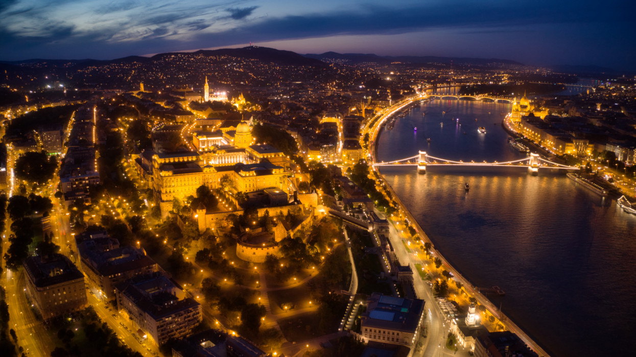 Aerial Drone View Twilight Scene of Budapest Cityscape, Hungary with the landmark Royal Palace of Buda illuminated at twilight.