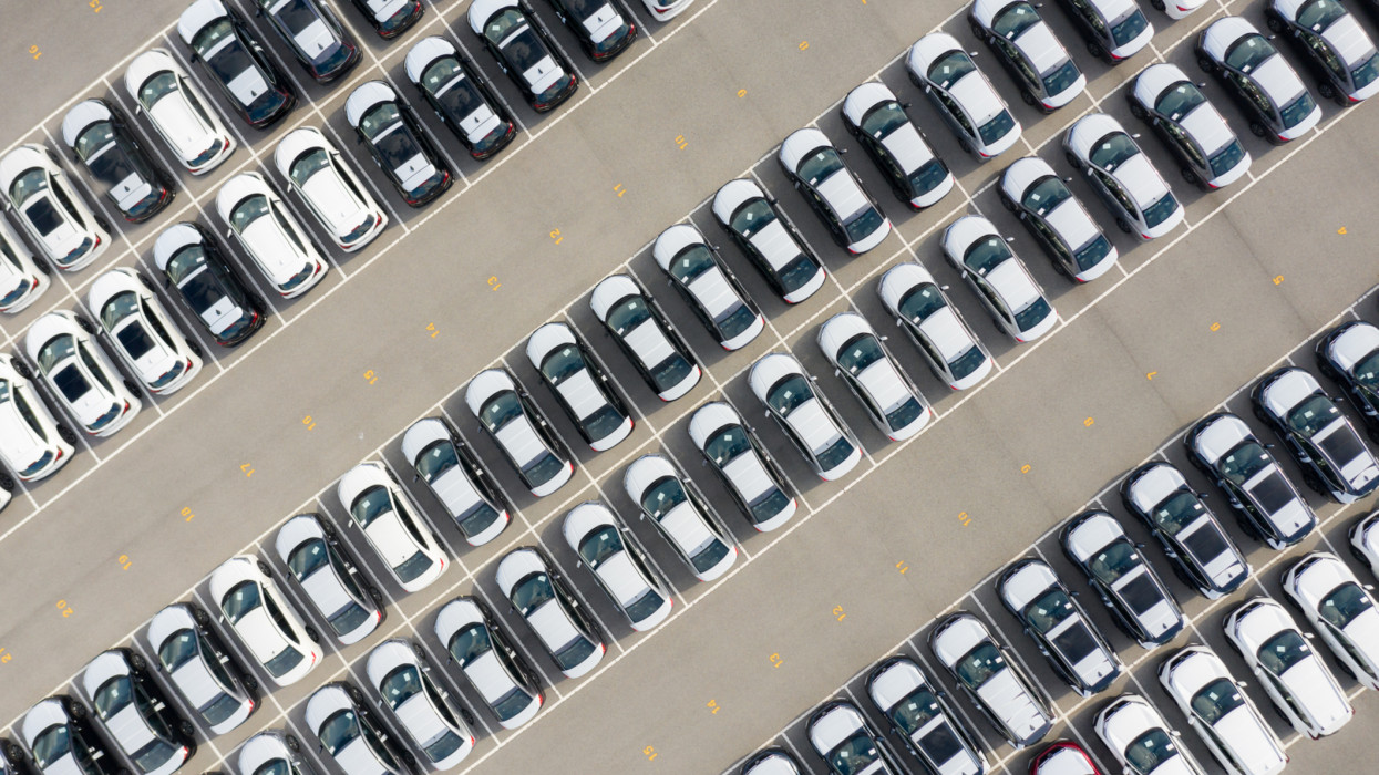 Aerial view new car lined up in the port for import and export business logistic to dealership for sale, Automobile and automotive car parking lot for commercial business industry.n
