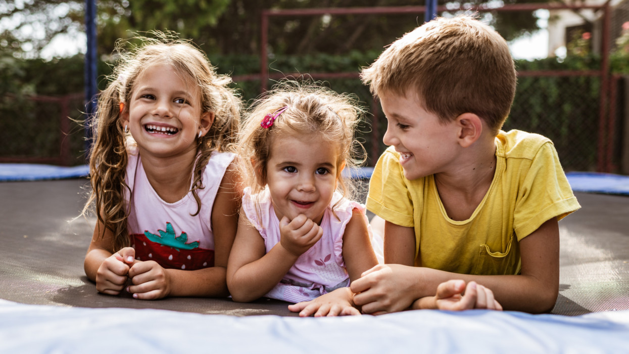 Beautiful siblings enjoying summer days. trampoline children kids smile summer camp