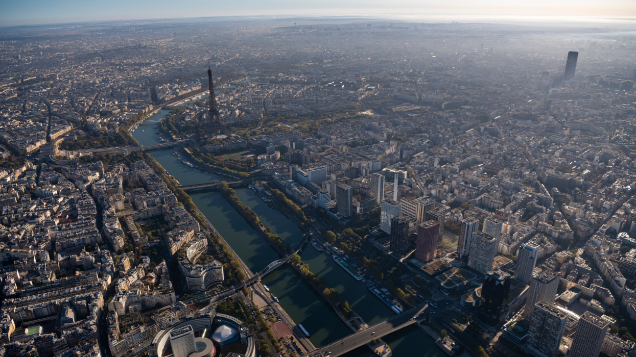 Aerial flying high up over Paris France looking North, East in the morning of a beautiful sunny day, view from a helicopter of the city below, Radio France - Maison de la radio, Seine river, Jardin des Tuileries, Tour Eiffel, Tour Montparnasse, and TrocadÃ©ro easily visible