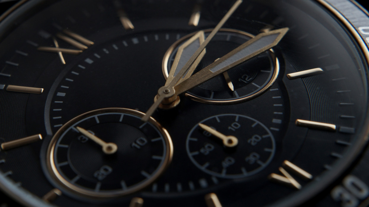 Close up of Black wrist watch with golden details
