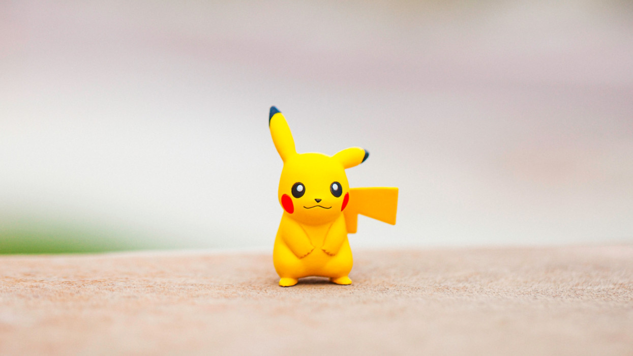 Peyton, Colorado, USA - August 17, 2016: A horizontal shot of the Pokemon Go character Pikachu, standing on top of a wall outdoors, in front of a defocused street in Peyton, Colorado. The figurine is made by Tomy.
