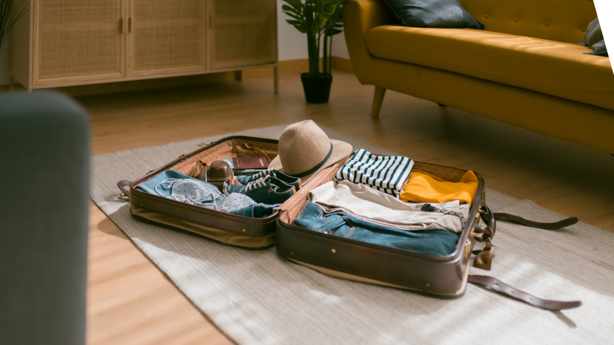 View of an open suitcase full of clothes ready to travel. Holidays and travel concept.