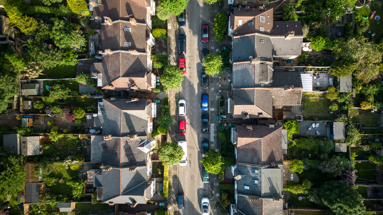 Overhead aerial view of residential homes and road with parked cars