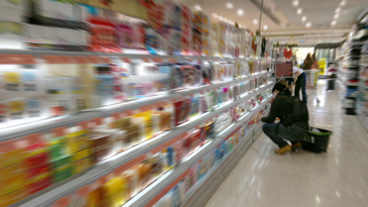 In Supermarket looking a woman at colorful goods. Blurred.