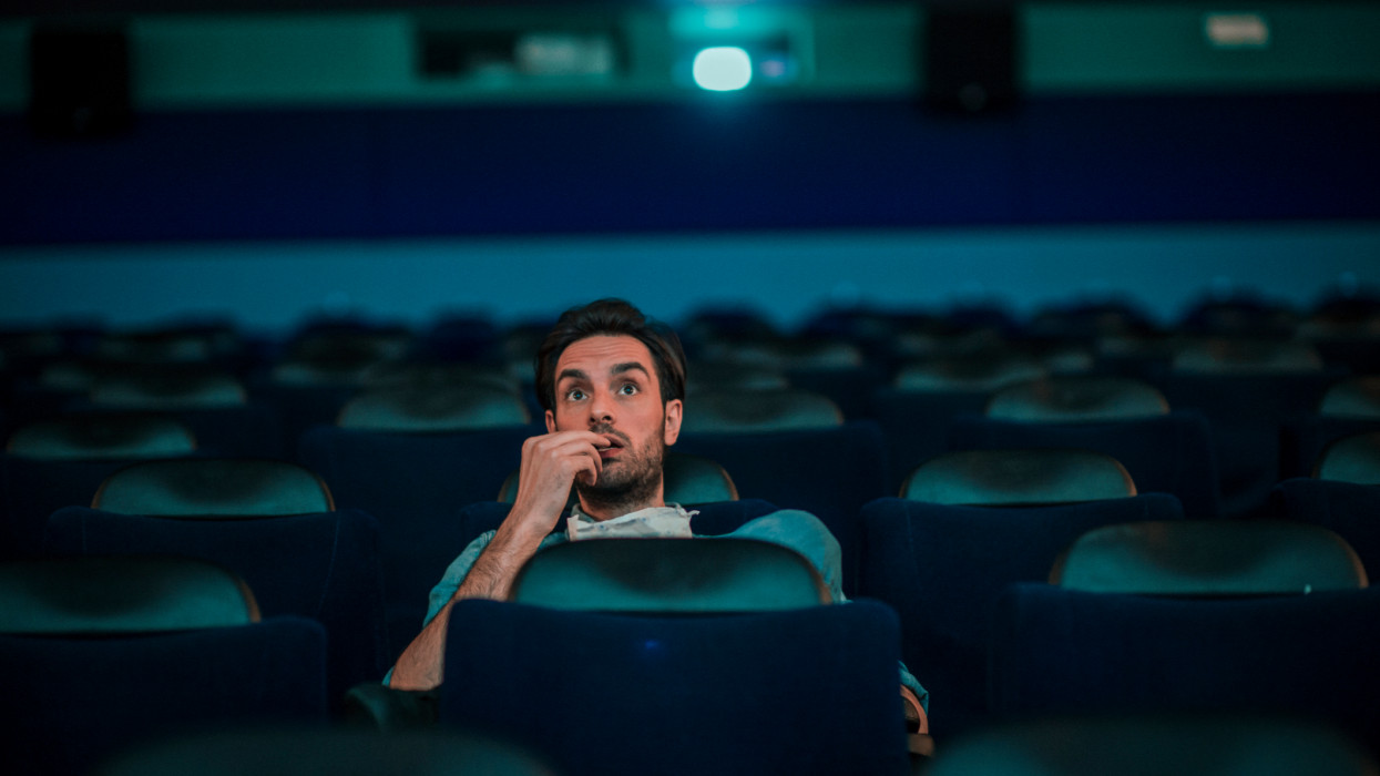 Shot of a young man watching a movie at the cinema