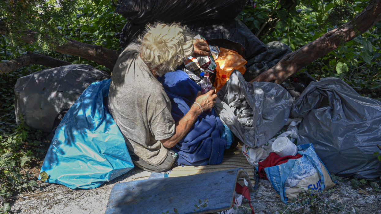 Budapest, 2021. július 22.Egy hajléktalan férfi, szállása és csomagjai  között táplálkozik egy bokor tövében, a fõvárosi Széll Kálmán tér közelében.MTVA/Bizományosi: Róka László ***************************Kedves Felhasználó!Ez a fotó nem a Duna Médiaszolgáltató Zrt./MTI által készített és kiadott fényképfelvétel, így harmadik személy által támasztott bárminemû  különösen szerzõi jogi, szomszédos jogi és személyiségi jogi  igényért a fotó szerzõje/jogutódja közvetlenül maga áll helyt, az MTVA felelõssége e körben kizárt.
