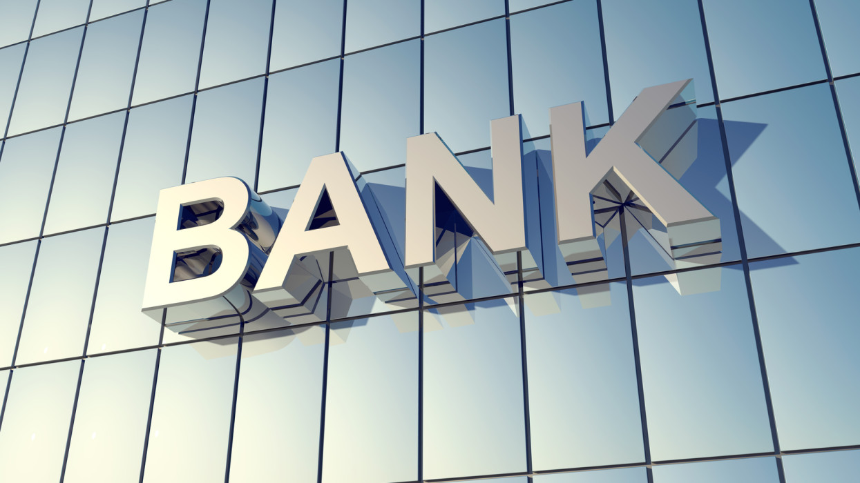 Glass front of a bank building with the word BANK on the Building