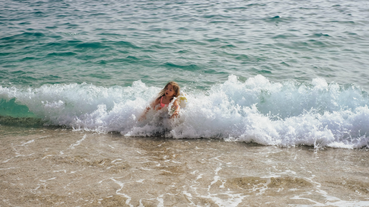 the girl was covered by a wave of the sea near the shore