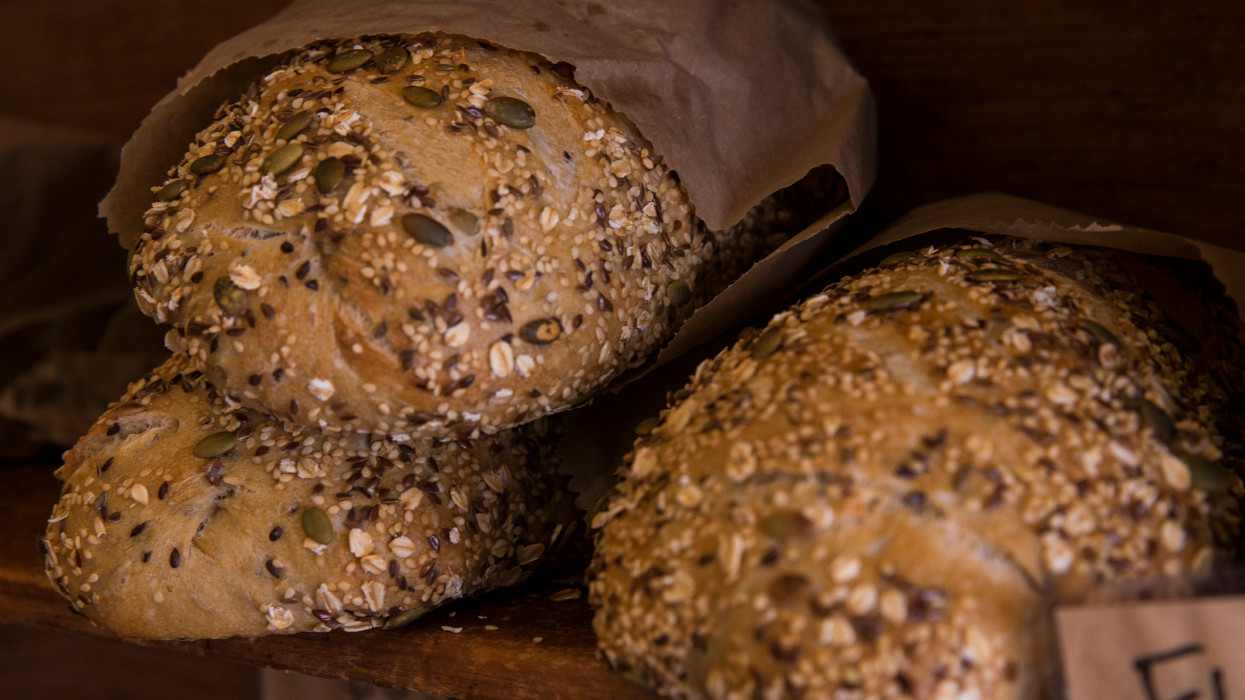 Three loaves of seed bread with rolled oats and pumpkin seeds in the crust.