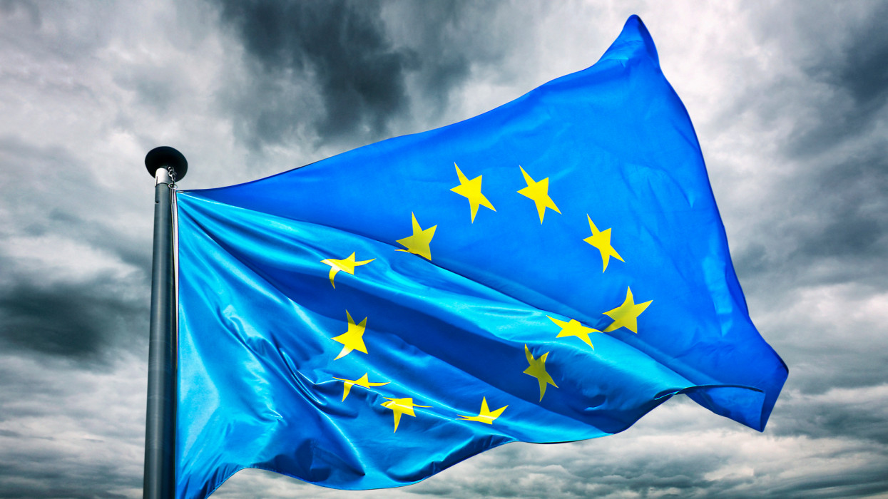 A European union or EU flag against a dark and powerful sky