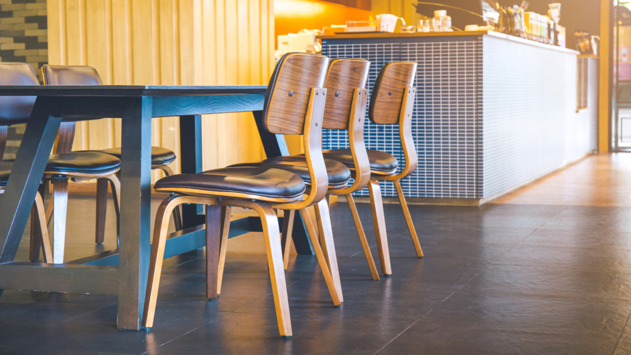 Table and wooden chairs in a modern coffee shop.Soft focus