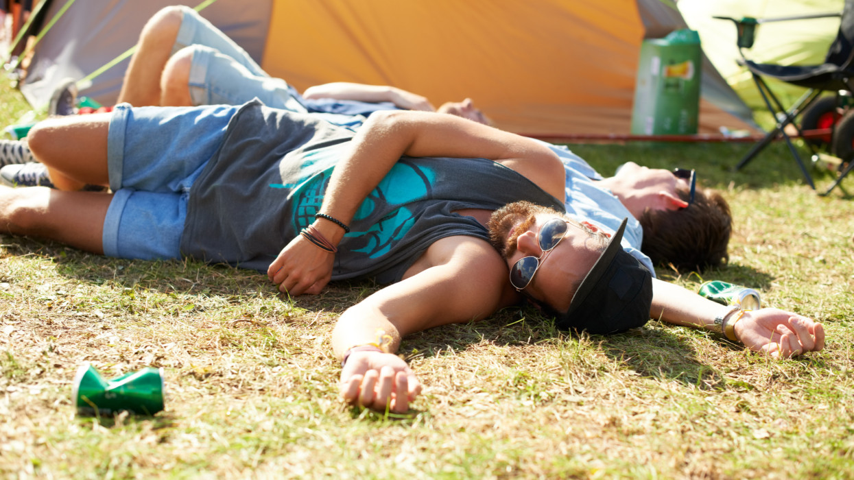 Shot of a two guys passed out on the grass after drinking too much at an outdoor festival hangover