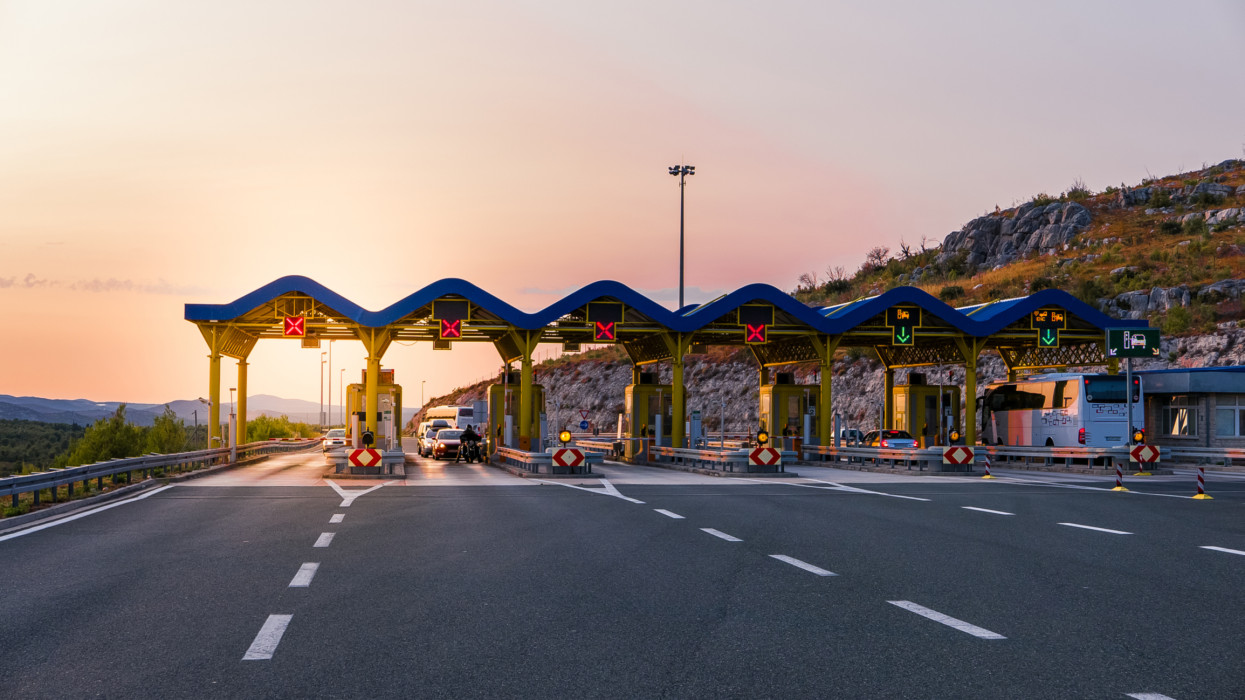 Cars passing through the toll gate on the motorway, vivid travel background
