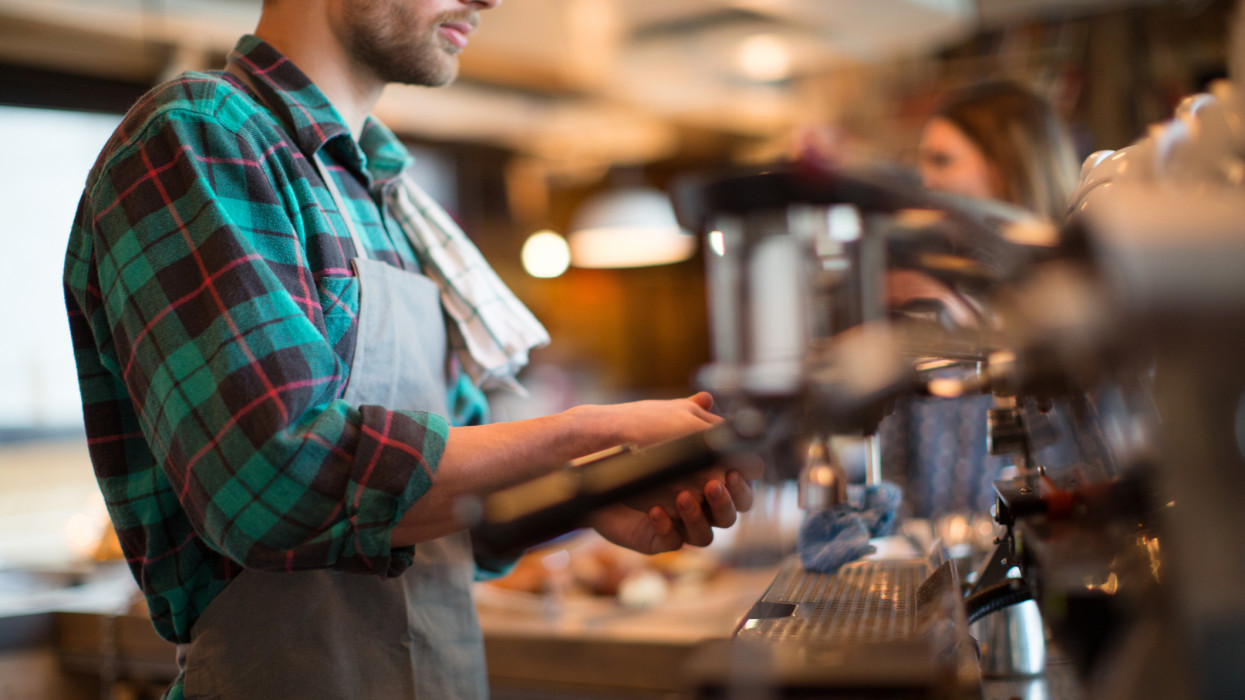 Side view midsection of man working in coffee shop