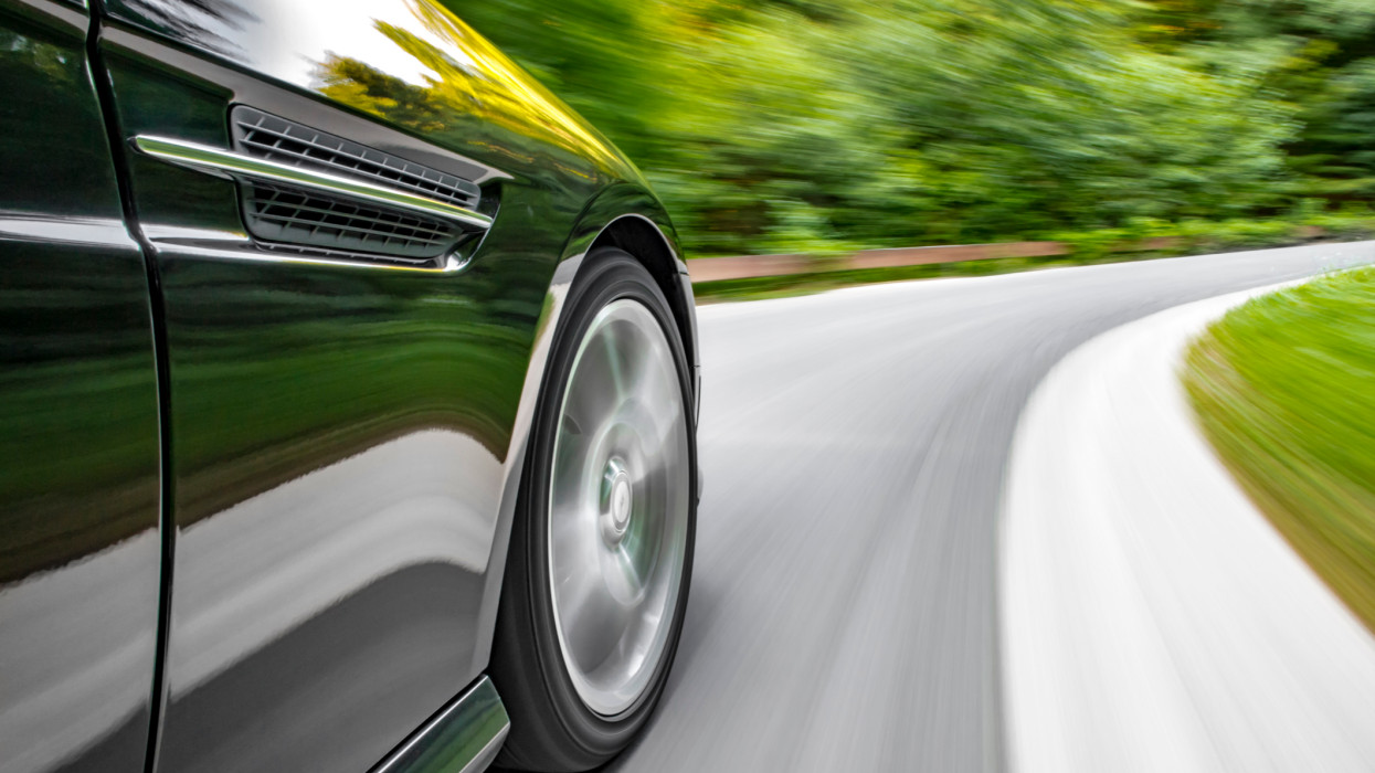 Motion blur shot of a sports coupe driving fast in a curve