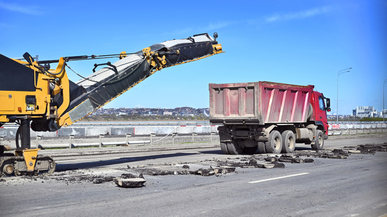 repair of a construction road cutting off old asphalt for the subsequent laying of a new roadbed