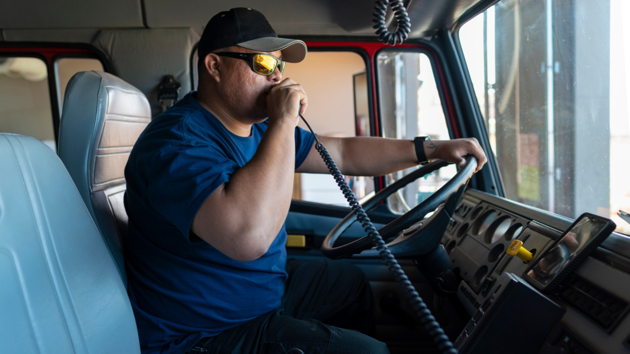 Indigenous Navajo Firefighter receiving a radio call on a  fire engine vehicle