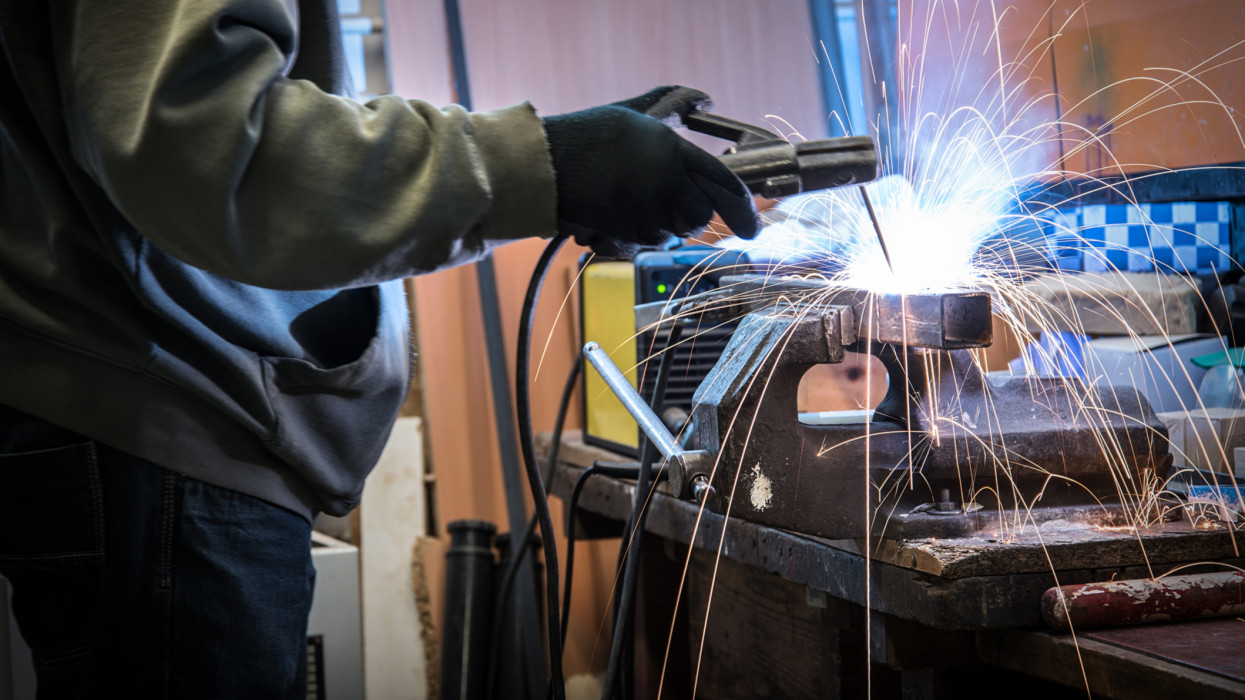 Industrial welder working a welding metal. Closeup photo