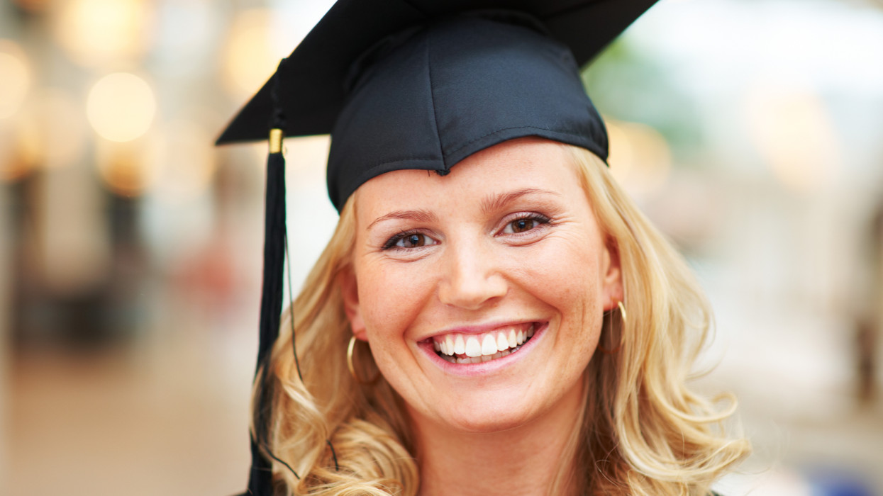 Close-up portrait of a smiling young graduate wearing mortarboard