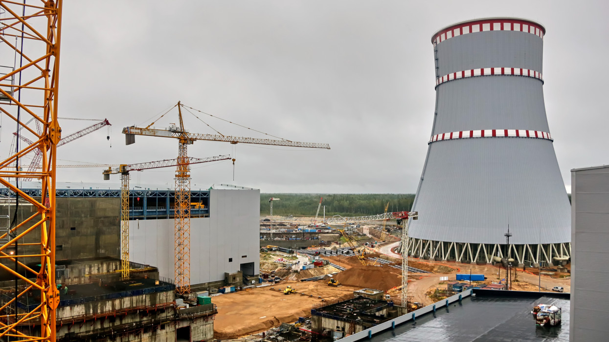 Construction of a nuclear power plant. Tower cranes on the background of the cooling tower.