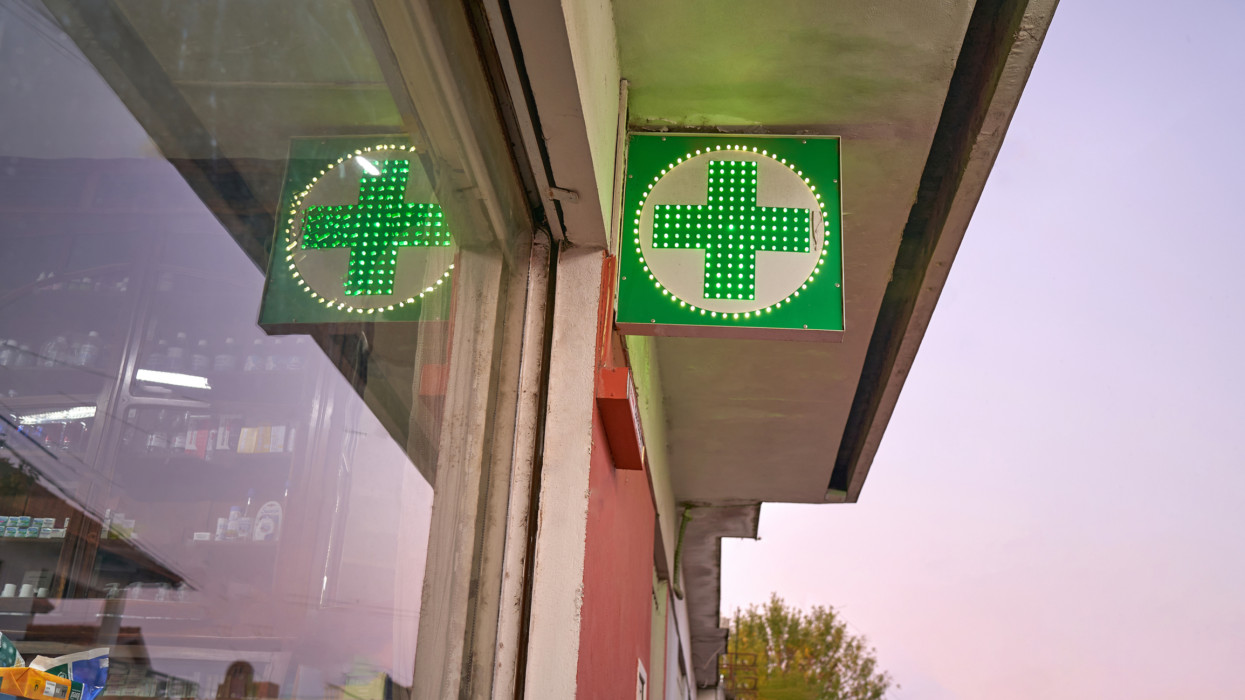 Pharmacy Neon Green Cross Sign at night.