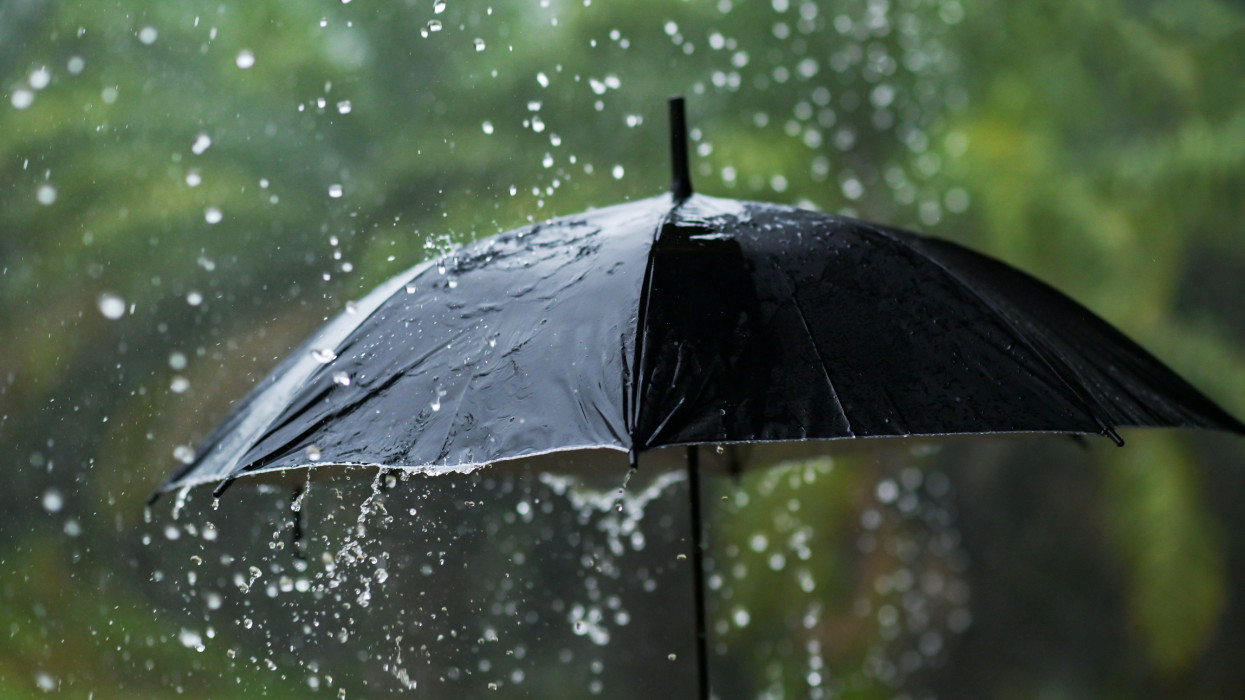 Erősen esik az eső, esernyő viselése esős évszakban
