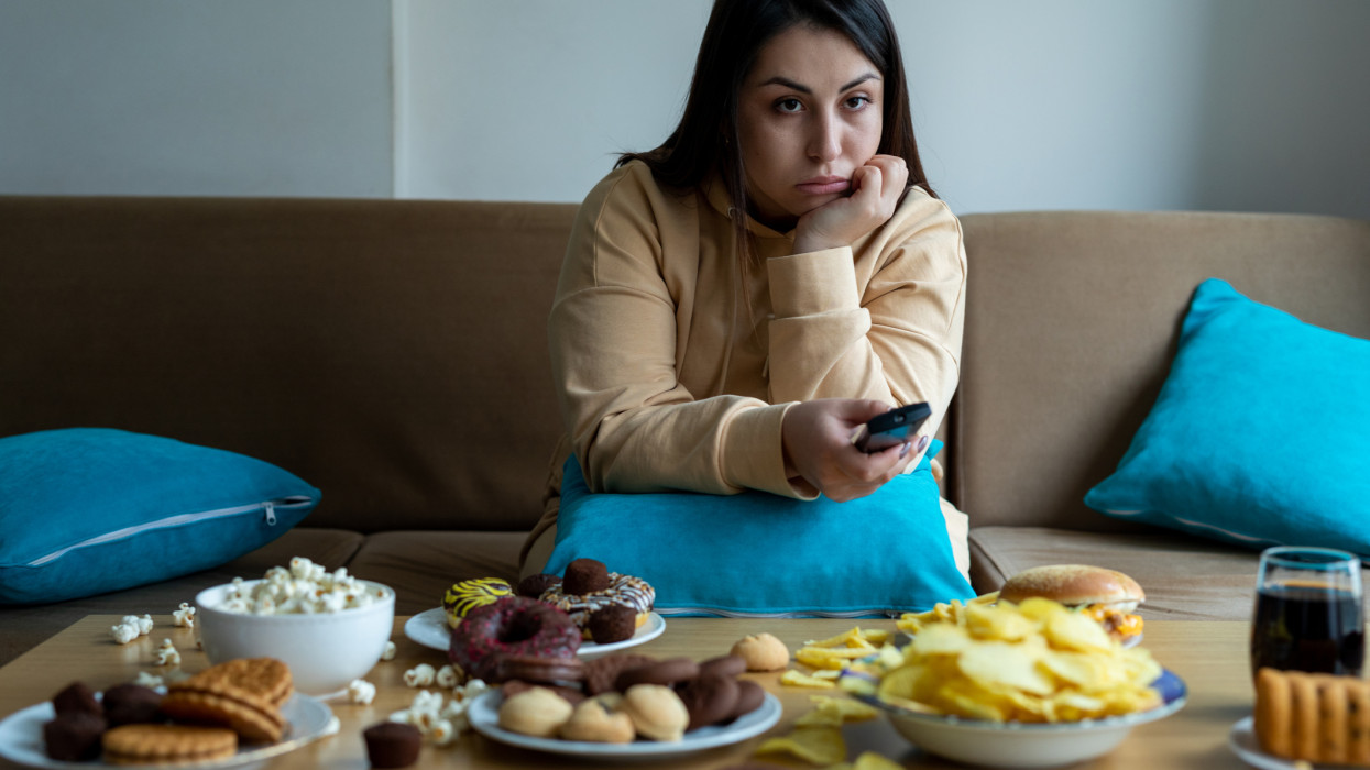 Overweight woman sitting on sofa cholesterol break up