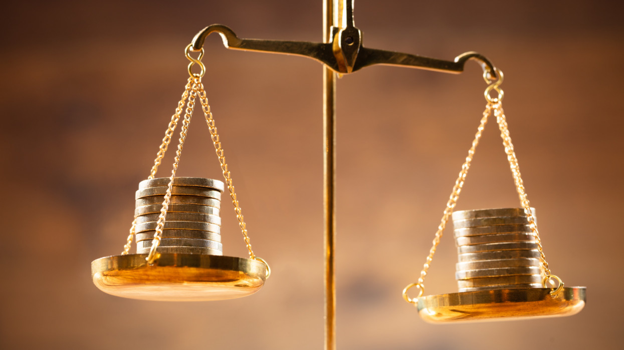 Close-up Of Golden Stacked Coins On Justice Scale balance libra