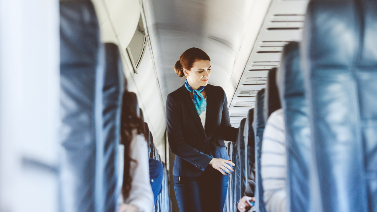 Beautiful air stewardess inside an airplane.