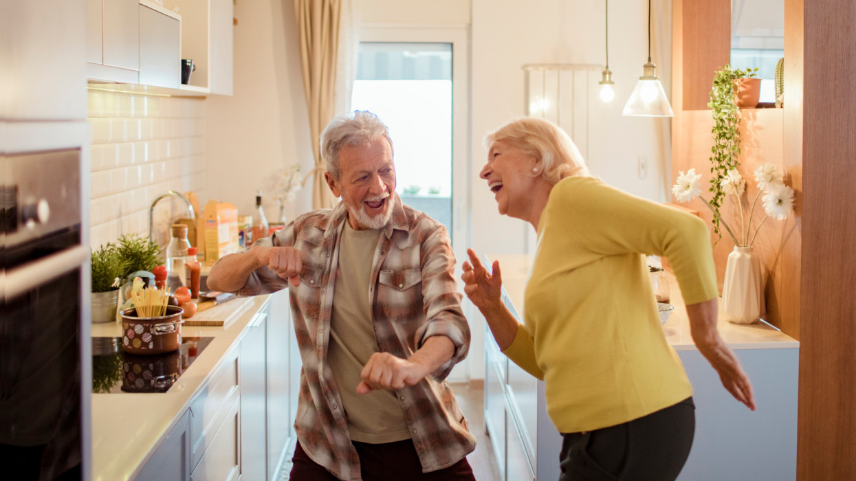 Close up of a senior couple dancing in the kitchen