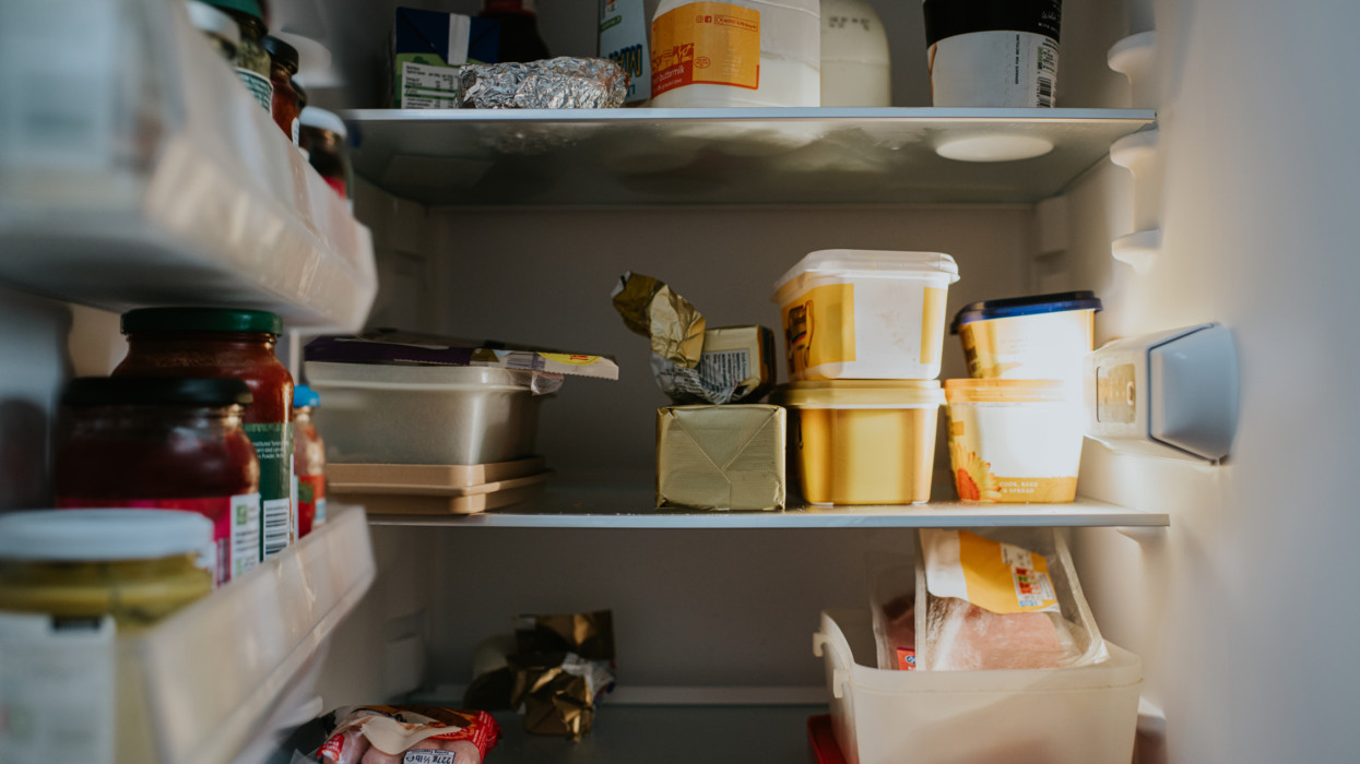 Conceptual image of the inside of a packed fridge, containing margarine, butter, dairy products such as milk and buttermilk and jars of food.
