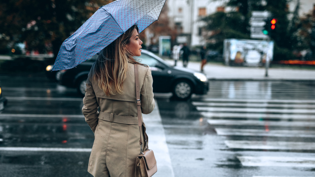 Beautiful woman with umbrella on a rainy day. wind