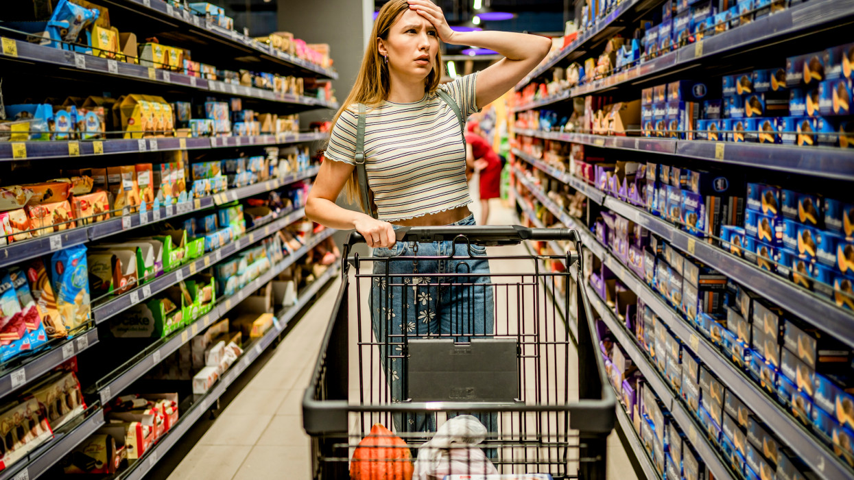 Young woman feeling shocked about rising grocery prices in the supermarket