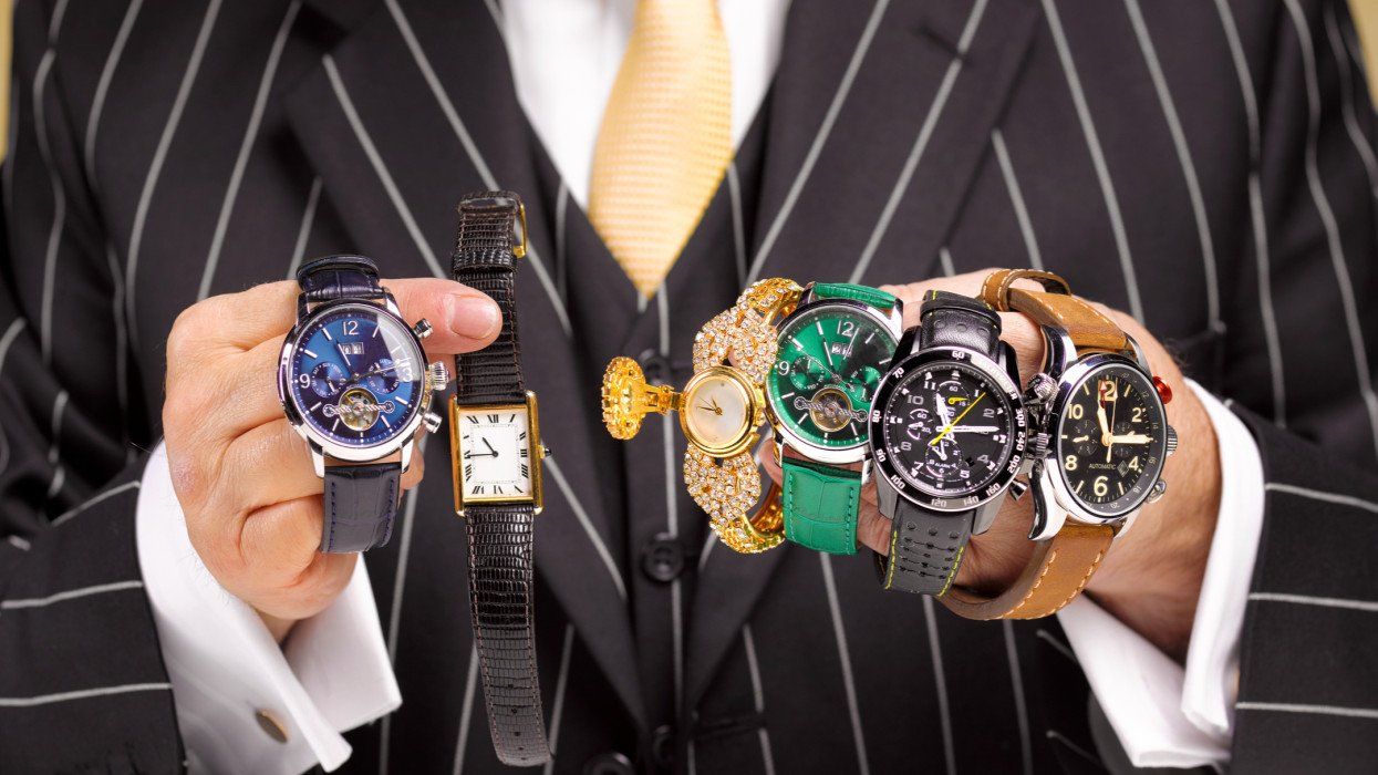 Close up of a black market traders hands with a collection of watches.