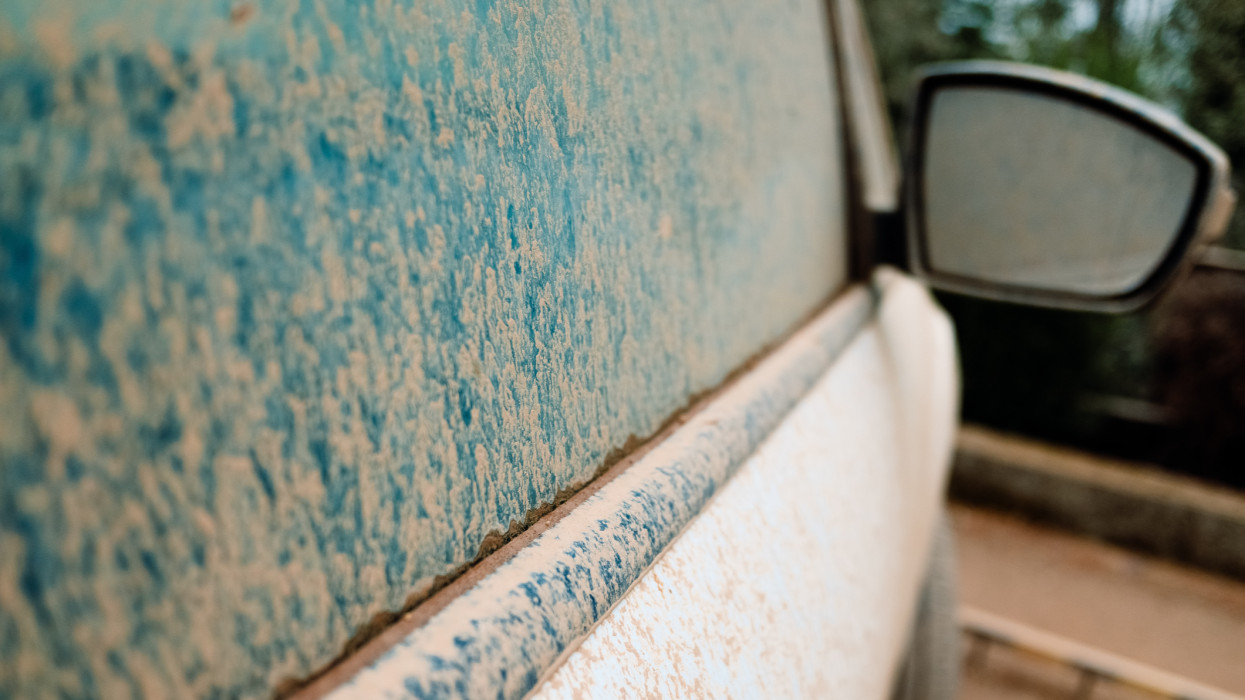 Detail of white cars very dirty from rains of mud, unwashed and neglected, covered in dust.