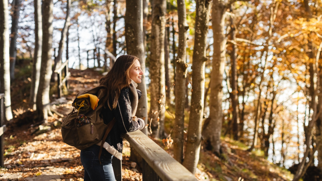 Hiker young woman enjoying the autumn forest